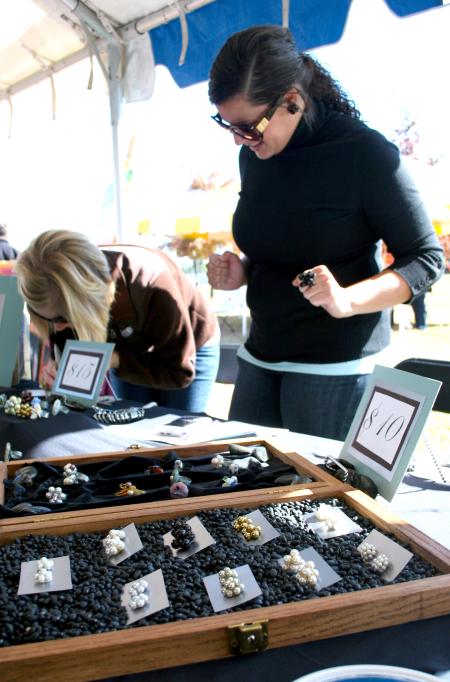 Rose Rogers, senior art major, takes orders for her handmade rings and other jewelry at Arts in the Park. - Photo by Kristi McMurry Woody
