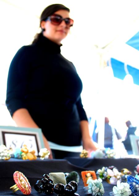 Rose Rogers, senior art major, takes orders for her handmade rings and other jewelry at Arts in the Park. - Photo by Kristi McMurry Woody