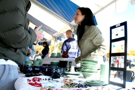 Alumni Amanda Bain, of Beech Bluff, Tennessee, sells her handmade jewelry and pottery at the annual Homecoming event, Arts in the Park. - Photo by Kristi McMurry Woody