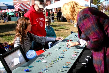 Reigning Miss Tennessee, Ellen Carrington, shows customers her handmade jewelry at the annual Homecoming event Arts in the Park.  - Photo by Kristi McMurry Woody