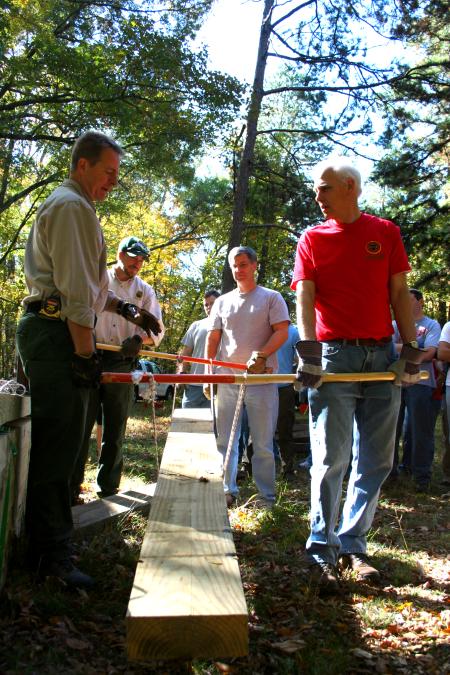 Stephen Carls and David Thomas of the history department help demonstrate how the pieces for a new bog bridge at Pinson Mounds would be transported.  The bridge was built as a part of the Day of Remembrance service projects.  - Photo by Kristi McMurry Woody