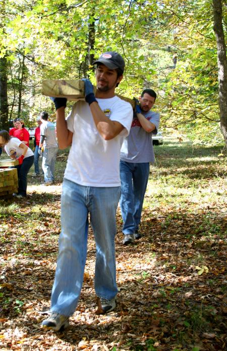 Joshua Hays, senior Christian ethics major, and Keith Bates, history professor, carry a cedar plank for placement in the construction of a simple bog bridge at Pinson Mounds during Day of Remembrance. - Photo by Kristi McMurry Woody