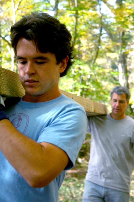Joshua Abbotoy, senior English major, and History professor David Thomas transport a long cedar plank to be placed as part of a bog bridge at Pinson Mounds.  The history department headed up this project for the Day of Remembrance. - Photo by Kristi McMurry Woody