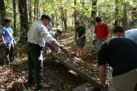 History students participated in a Day of Remembrance project at Pinson Mounds that lay a temporary bridge over a muddy area. - Photo by Kristi McMurry Woody