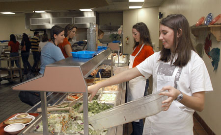  Freshman Stacie Scholl (right) and  Sophomore Anna White  (center) serve food to their fellow Unionites in the cafeteria.  They were among several students who volunteered to fill in for workers whose homes were damaged by the tornado.
 - Photo by Jim Veneman