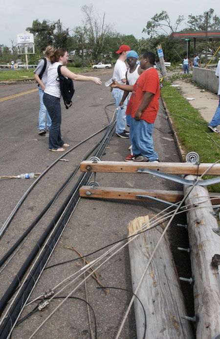 Freshman Shaundra Bloomberg crosses downed power lines to hand out bottled water to East Jackson residents. - Photo by Jim Veneman