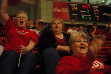 Union fan Dot Cupples shakes her pom-poms with excitement as her friends Pam Coughlin (top right) and Sherrell Dorris cheer during the second half of the Lady Bulldog's first game of the NAIA National Tournament on Wednesday.  - Photo by Beth Spain