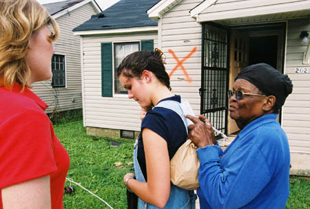 Sophomore Stephanie Ozier serves as a writing surface for a tornado victim to fill out a needs survey. - Photo by Justin Veneman