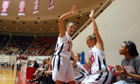 Kaitlin Dudley and Kayla Hudson high-five after their teammate, Sarah Chan, makes a basket during the semifinals of the 2009 NAIA tournament. - Photo by Kristi McMurry Woody