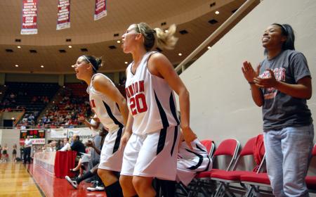 Kaitlin Dudley, Kayla Hudson and Jessica Graves cheer on their team during the semifinals of the 2009 NAIA tournament. - Photo by Kristi McMurry Woody