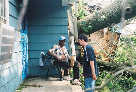 Sophomore Matt Dickey talks with a local tornado victim and gives him a sandwich and bottled water. - Photo by Justin Veneman