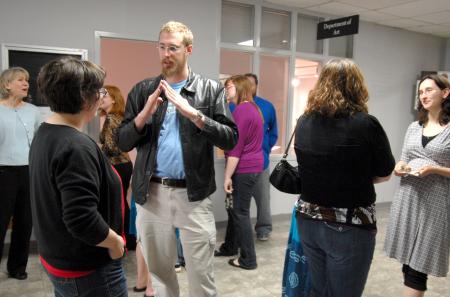 Chris Malloy, junior art major, chats with Melinda Eckley, assistant professor of art, at the annual student art show reception.  - Photo by Kristi McMurry Woody