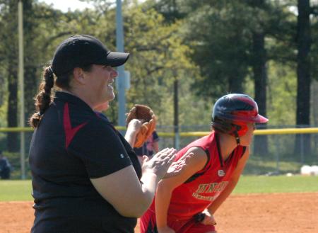 Head Coach Heather Hall give instructions from the third base coaching box as freshman Ali Bozza gets ready on third base. - Photo by Steven Aldridge