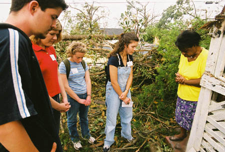 Union students pray with a tornado victim in South Jackson who lost her home. - Photo by Justin Veneman