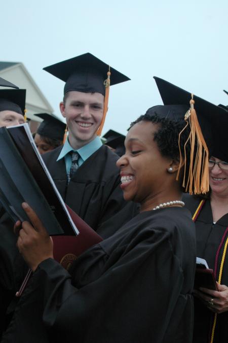 Nursing graduate Amber-Rose Hawkins and Kyle Odom sing the Alma Mater at the end of the spring graduation ceremony. - Photo by Beth Spain