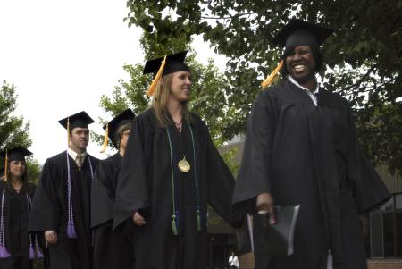 Graduates Santeia Kinnon and Heather Martin are joyful as they walk to the spring graduation ceremony on the Great Lawn. - Photo by Sarah Palmer Goff