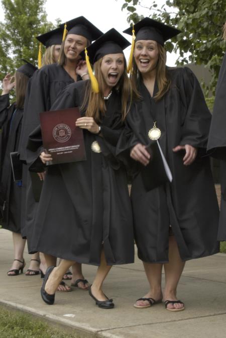 Alaina Baire and Jessica Bandy celebrate as they make their way to the Great Lawn for spring graduation. - Photo by Sarah Palmer Goff