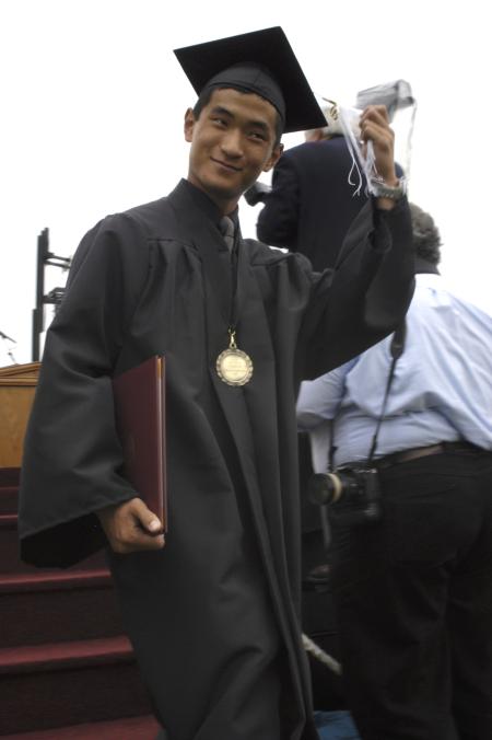 Danny Song transfers his tassel after he receiving his diploma during spring graduation. - Photo by Sarah Palmer Goff