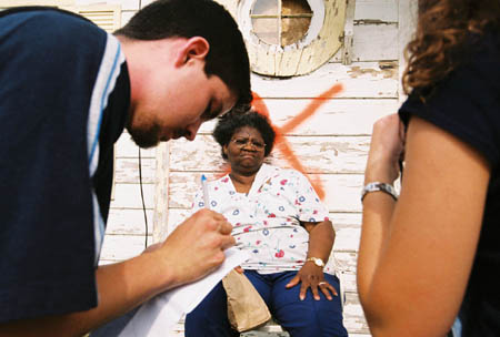 Sophomore Matt Dickey writes down tornado victim Jimmie Williams' needs while ministering in downtown Jackson.
 - Photo by Justin Veneman
