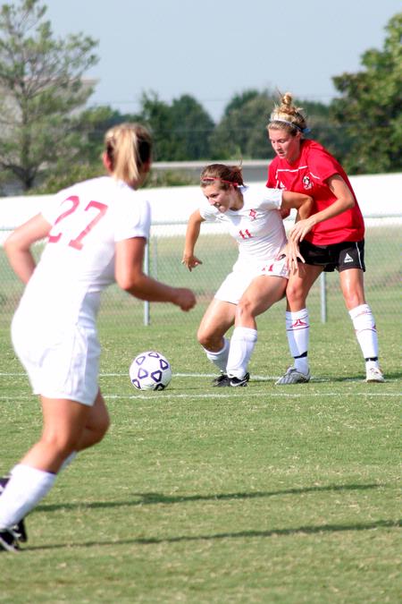 Steffi King, freshman, keeps the ball away from her Christian Brothers opponent as Katelin Dirksen (27) moves into position. - Photo by Kristi McMurry Woody