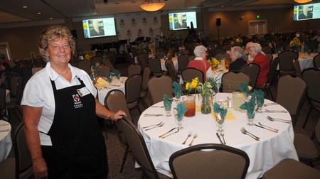 Anna Clifford, associate professor of early childhood education, poses by one of the tables set for the Faculty/Staff Dinner that her committee helped plan. - Photo by Morris Abernathy