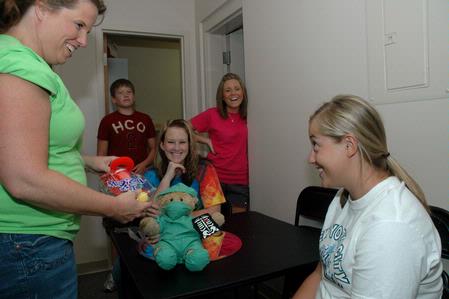 Rebecca Green, sophomore math major, receives a toy bear and nurse kit from her roommates mother Michelle Fry during returning student move-in day. - Photo by Beth Spain