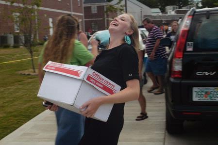 Katherine Pullen, sophomore ICS/Journalism major, laughs as she moves boxes into her room in the Quads. - Photo by Sarah Palmer Goff