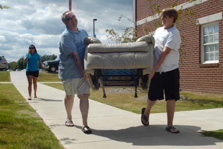 Ray, father of Taylor Burks, sophomore accounting major, and son Matt help move furniture into Taylor's room in the Quads. - Photo by Sarah Palmer Goff