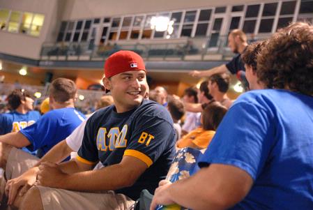 Alex Shepherd, junior business administration major, watches the Diamond Jaxx game and fellowships with friends at Pringles Park on college night.  - Photo by Kristi McMurry Woody
