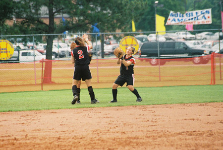 Amanda Dixon (1) breaks for her position in right field.  Allison Shein (2) and Holly Haycraft (not seen) head for left and center field respectively.  2003 NAIA Softball World Series in Decatur, Ala. - Photo by Steven Aldridge