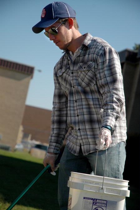 Joshua David Creswell, junior philosophy major, picks up trash at the Hartland Place apartments during Campus and Community Day. - Photo by Beth Spain