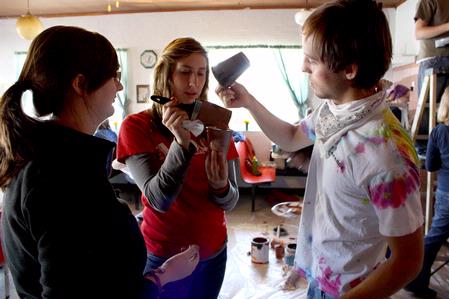 Kate Allen, sophomore graphic design major, Maddie Russo, sophomore elementary education major, and Caleb Booth, junior art major, carefully mix paint for the mural at Daddy's Kitchen Table Soup Kitchen on Campus and Community Day. - Photo by Megan Bailey