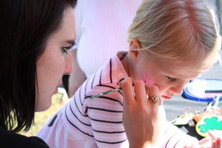 Anna Elrod, freshman athletic training major, paints a butterfly on the face of Kendall Morris, 4, at the Kappa Delta tent during Arts in the Park for Homecoming 2009. - Photo by Megan Bailey