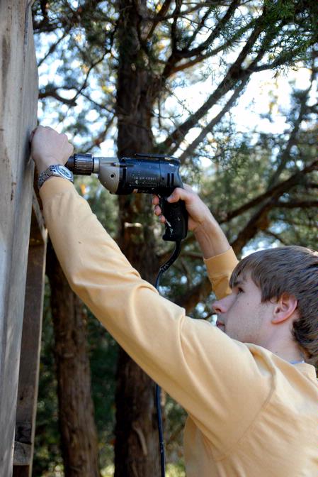 Kevin Reid, junior history major, helps build a replica outhouse for Green Frog Village as a part of Campus and Community Day.  - Photo by Kristi McMurry Woody
