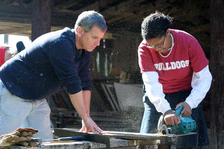 David Thomas, professor of history, and Glenae Nora, freshman history major, cut a board to be used for a building project at Green Frog Village. The history department did several projects for Green Frog on Campus and Community Day.  - Photo by Kristi McMurry Woody