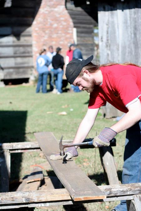 Travis Lutz, junior history major, works on a building project for Green Frog Village on Campus and Community Day. - Photo by Kristi McMurry Woody