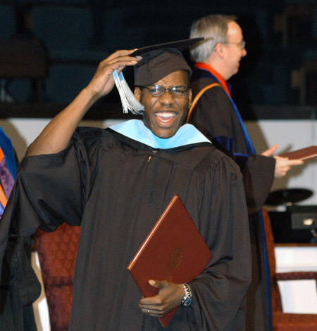 After receiving his Master of Education degree at the August 2003 commencement exercises, Joshua Duncan celebrates by ceremonially moving his tassle. - Photo by Jim Veneman