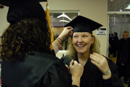 Laura Byrd helps fellow nursing graduate Krystal Watkins adjust her cap before the fall graduation ceremony. - Photo by Sarah Palmer Goff