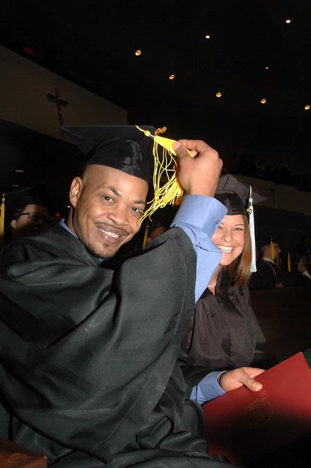 Marshal Brown, physical education and health graduate, switches his tassel from right to left as Ashley Bugg, learning foundations graduate, looks on during fall graduation. - Photo by Beth Spain