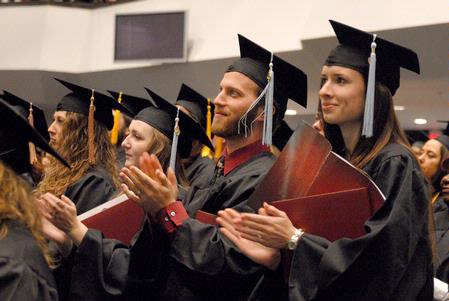 Andrew and Jennifer Boom, education graduates, clap in celebration at fall graduation.  - Photo by Kristi McMurry Woody