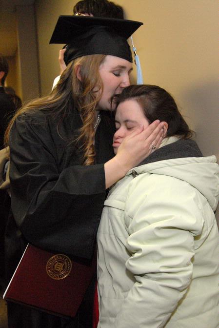 Emily Babin Campbell gives her sister, Elizabeth Babin, a kiss after graduating with a bachelor of science in special education at fall graduation.  - Photo by Kristi McMurry Woody