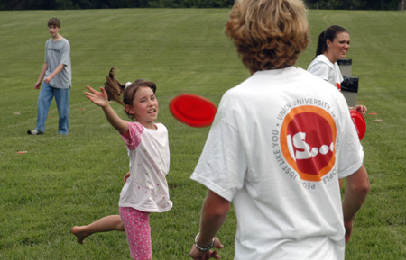 Sophomore Brad Spencer plays frisbee with a youngster at a Steven Curtis Chapman Brown Bag concert sponsored by Union in Franklin, Tenn.  - Photo by Jim Veneman