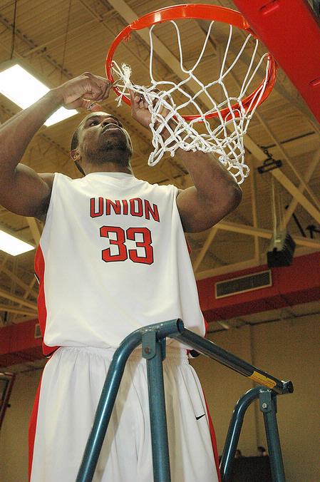 Freshman Samuel Danache cuts the net after winning the TranSouth Tournament in a game against Freed Hardeman University. - Photo by Jordan Buie