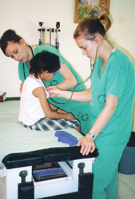 Nursing students Kari Noblett and Amy Rennie provide basic physicals and treat minor illnesses for children at Orphanage Emmanuel while serving on the GO Hondurus team. - Photo by Uncredited