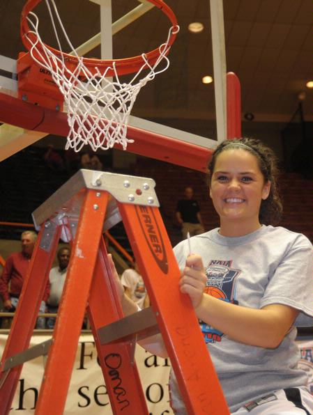 Kayla Bryant, junior, cuts a piece of the net after the Lady Bulldogs defeated Azusa Pacific University to become NAIA Division I National Champions. - Photo by Morris Abernathy