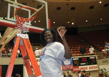 Beatrice Awino Duol, junior, cuts a piece of the net after the Lady Bulldogs defeated Azusa Pacific University to win the NAIA National Tournament. - Photo by Morris Abernathy