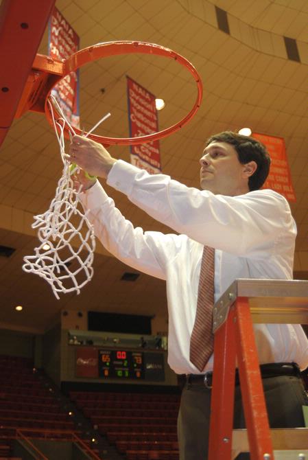 Mark Campbell, head coach, cuts a piece of the net after the Lady Bulldogs defeated Azusa Pacific University to become NAIA Division I National Champions. - Photo by Morris Abernathy