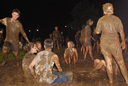 Students play games in the huge mud puddle created by Young Alums for Midnight Mudness. This event gives students a fun activity to celebrate the end of a semester.  - Photo by Abigail Harris
