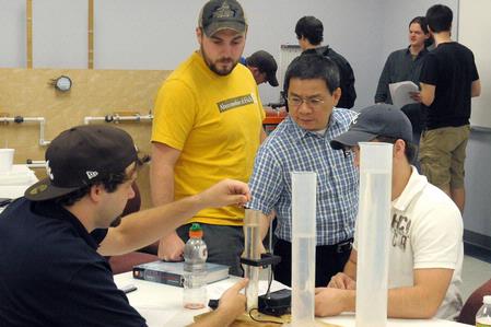 Dr. Don Van, professor of engineering and department chair, helps a group of students with a lab assignment. - Photo by Morris Abernathy