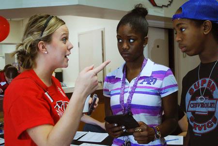 Amy Brown, enrollment counselor, talks to Aneice Lunsford, incoming freshman, and her brother Andrie about the schedule for Move In Day.  - Photo by Abigail Harris